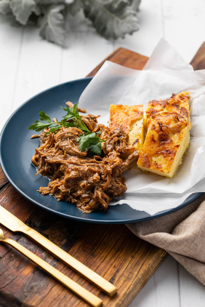 Indulge in our Southern Texas Style BBQ Pulled Pork, accompanied by a garlic-infused Potato Gratin and seasonal vegetables, a satisfying meal for one